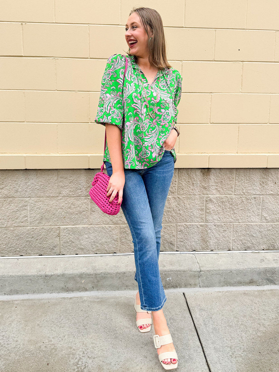Green and pink paisley print blouse with frilled tie neckline and three-quarter peasant sleeves displayed on hanger against a neutral background