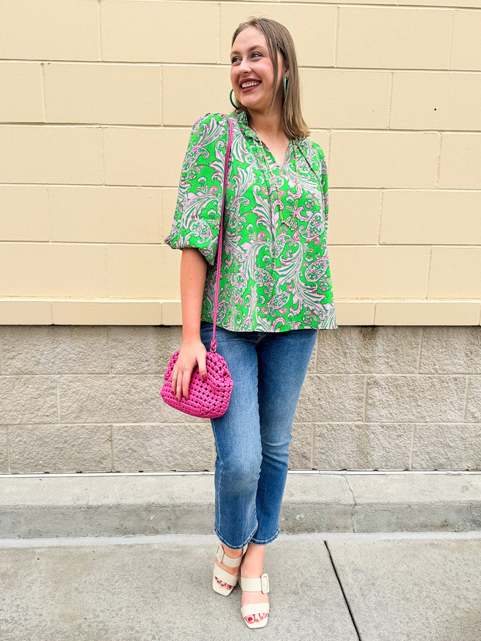 Green and pink paisley print blouse with frilled tie neckline and three-quarter peasant sleeves displayed on hanger against a neutral background