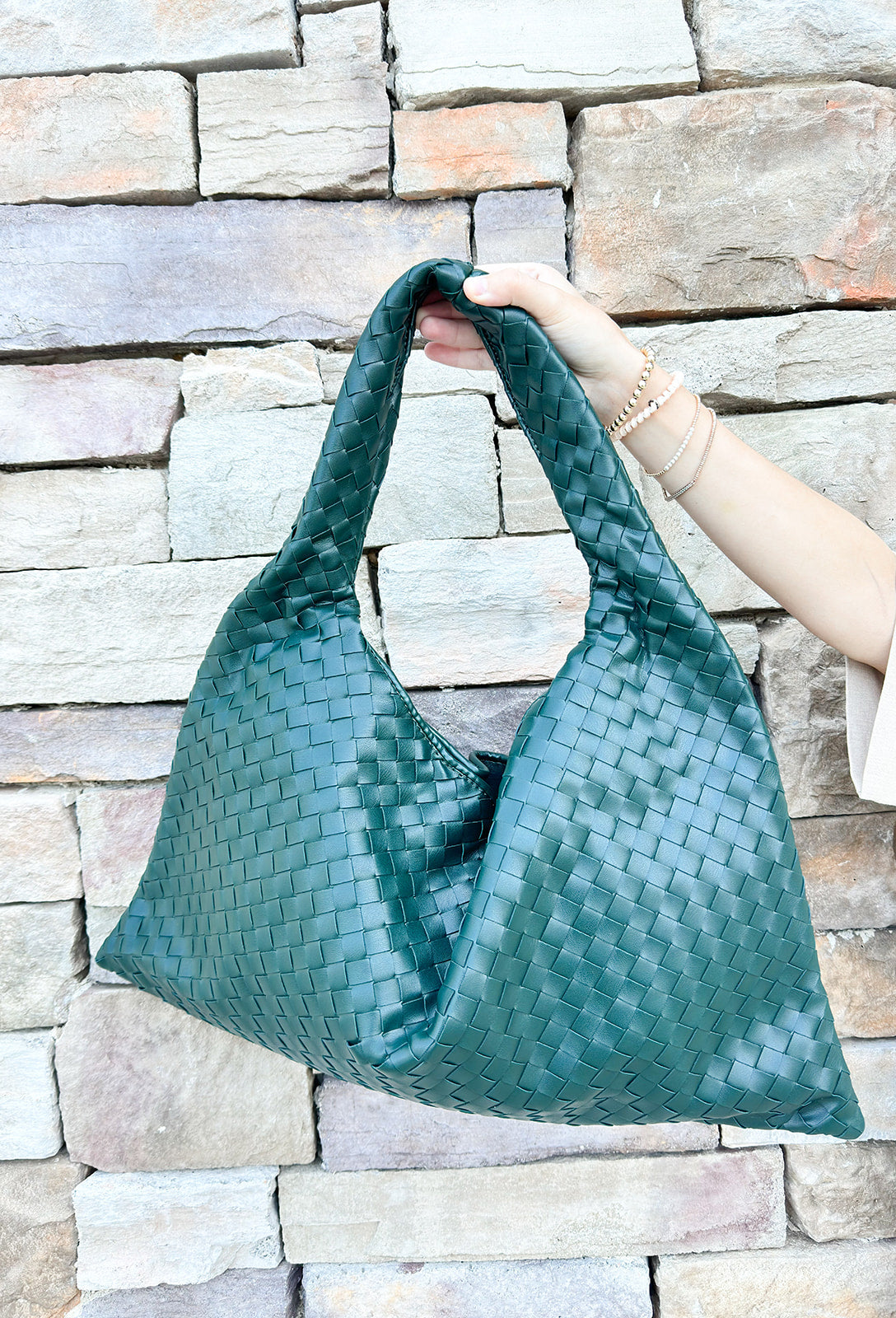 Green woven shoulder bag with soft structure and magnetic closure, designed for stylish and functional everyday use