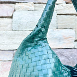 Green woven shoulder bag with soft structure and magnetic closure, designed for stylish and functional everyday use