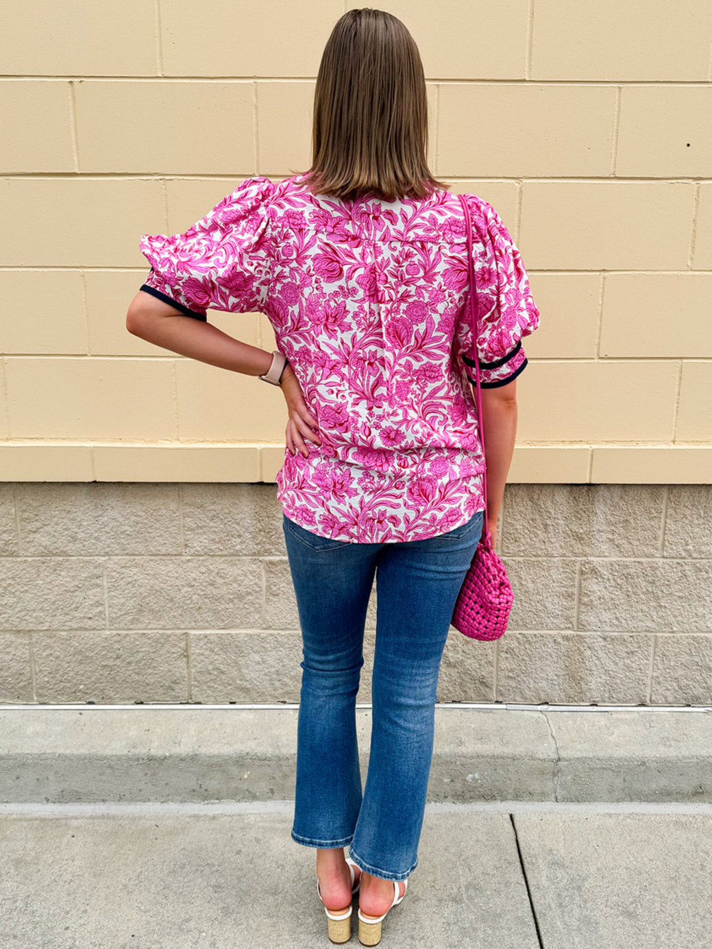 Pink caftan-style top with split neckline and botanical floral print, lightweight and relaxed fit