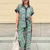Floral paisley button-down blouse with navy collar, pink trim, high-low hem, and navy-trimmed sleeves—lightweight and chic