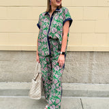 Floral paisley button-down blouse with navy collar, pink trim, high-low hem, and navy-trimmed sleeves—lightweight and chic