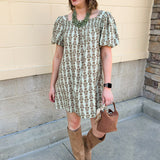 Light olive smocked mini dress with tonal floral print, puff sleeves, and square neckline