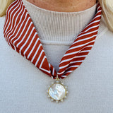 Rust and cream striped scarf necklace with pearl-inspired resin sun charm, handmade by Hart Designs.