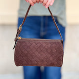 Chocolate brown cylinder-shaped shoulder bag with adjustable buckle strap and zip closure.