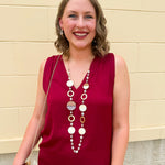 Long oatmeal-colored necklace with mixed circle and bead design, featuring neutral stones and delicate chain