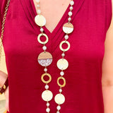 Long oatmeal-colored necklace with mixed circle and bead design, featuring neutral stones and delicate chain