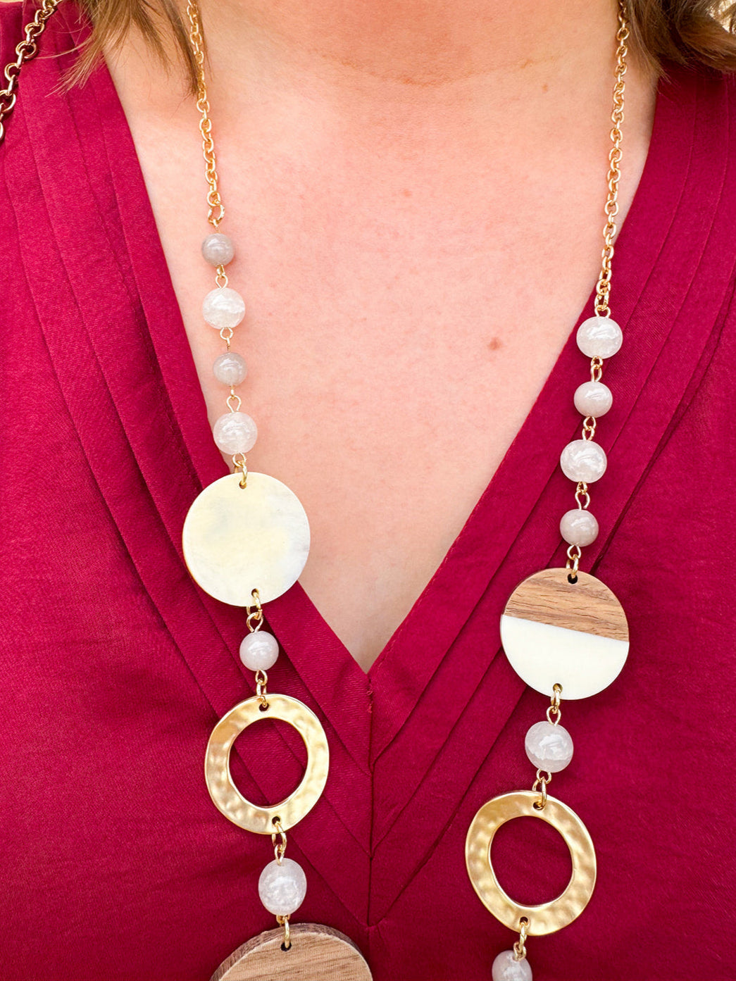 Long oatmeal-colored necklace with mixed circle and bead design, featuring neutral stones and delicate chain