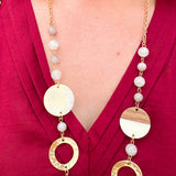 Long oatmeal-colored necklace with mixed circle and bead design, featuring neutral stones and delicate chain