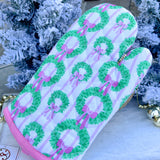 White oven mitt with green wreath and pink bow pattern, pink piping trim.