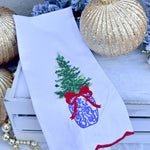 White tea towel with blue and white ginger jar Christmas tree, red bow, and red scalloped trim.