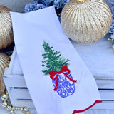 White tea towel with blue and white ginger jar Christmas tree, red bow, and red scalloped trim.