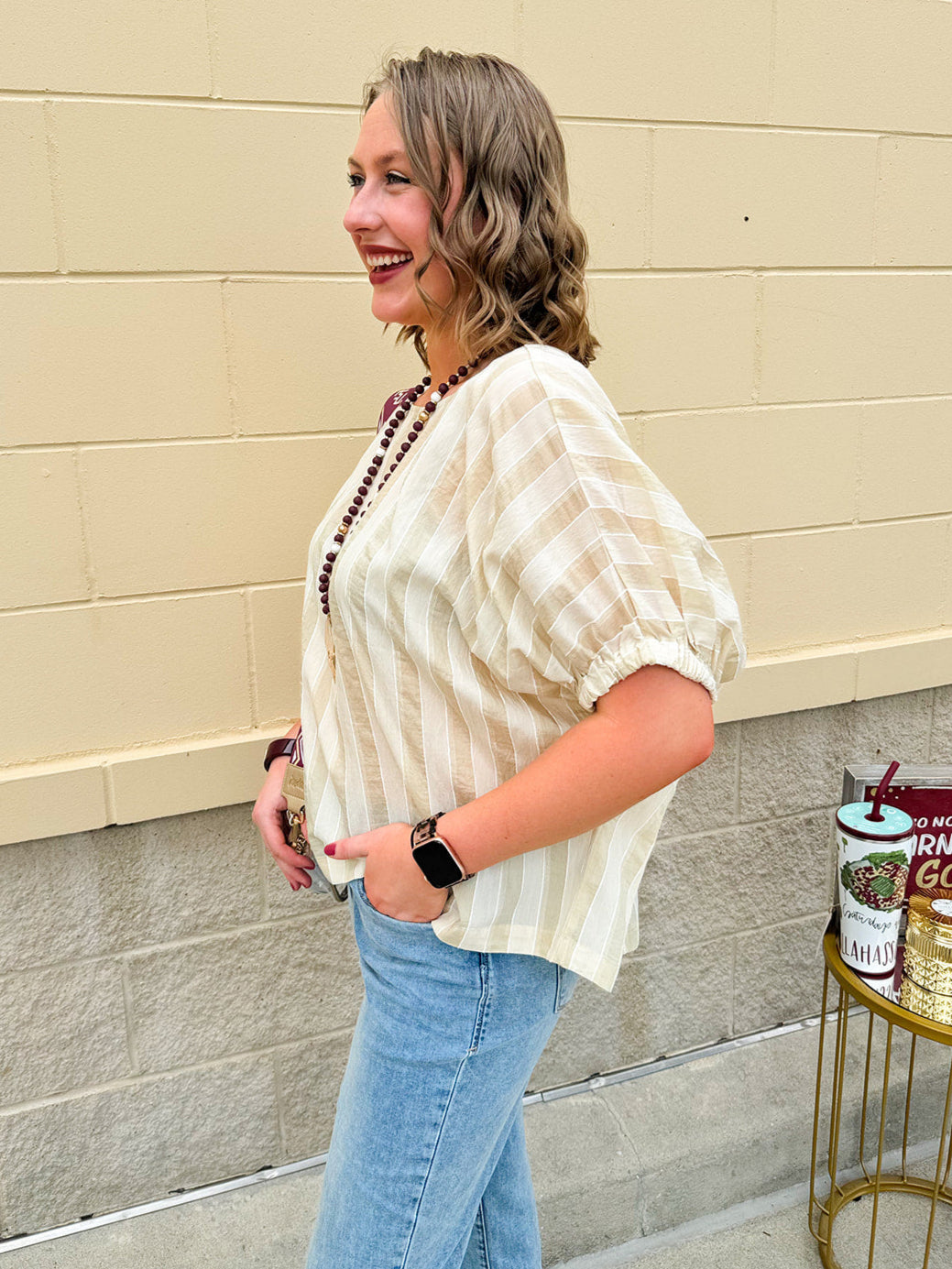 Cream and gold striped round-neck top with dolman sleeves and elastic cuffs, styled for summer.