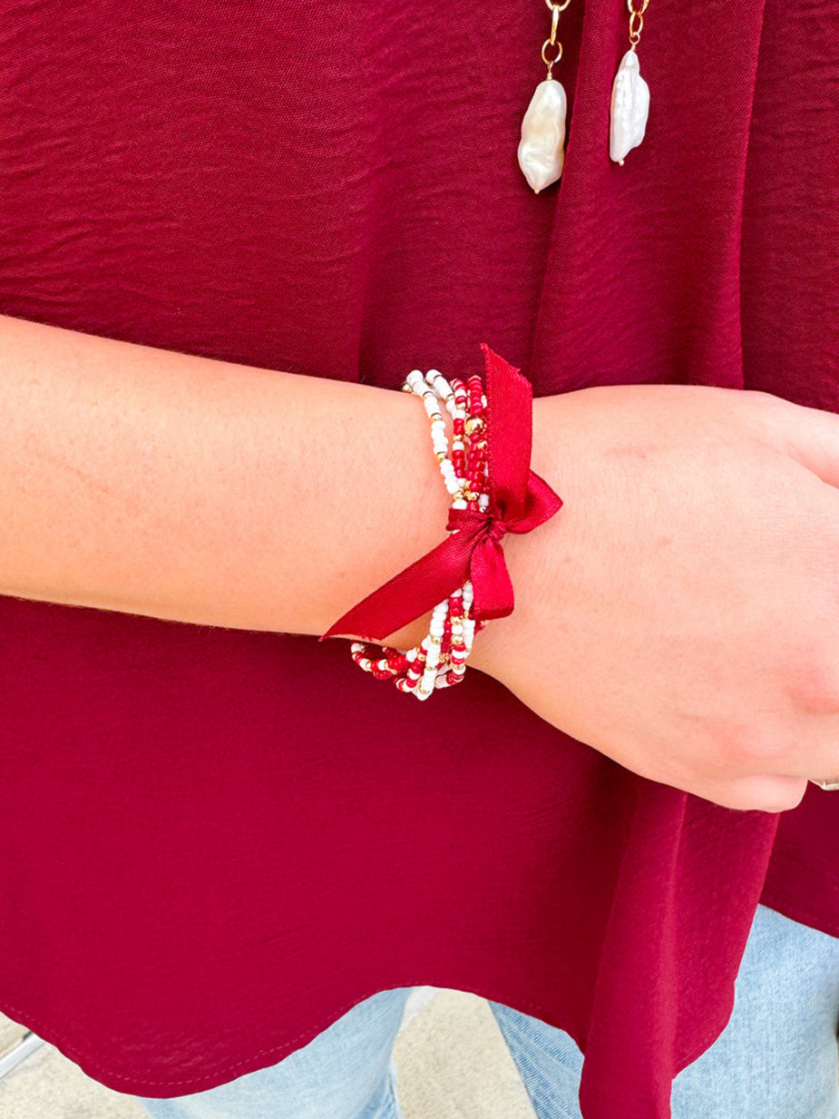 Multi-strand garnet, white, and gold beaded bracelet with satin ribbon tie