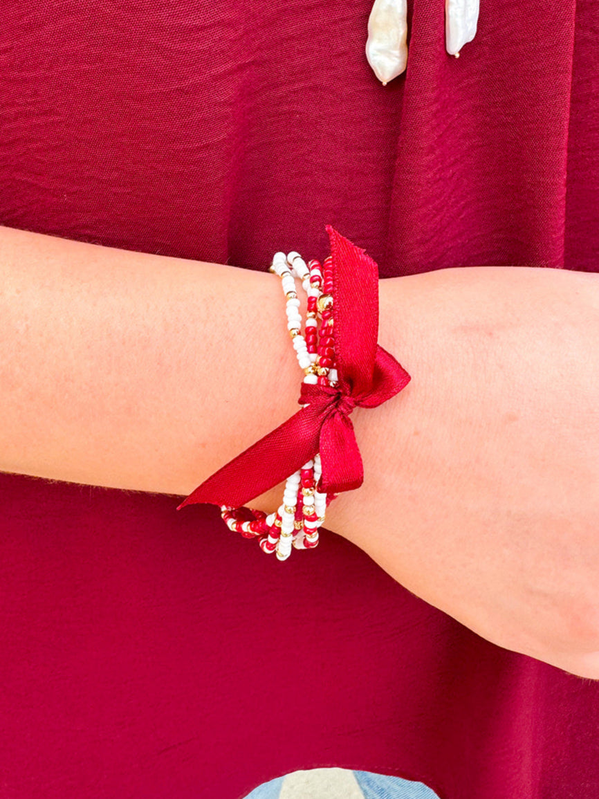Multi-strand garnet, white, and gold beaded bracelet with satin ribbon tie