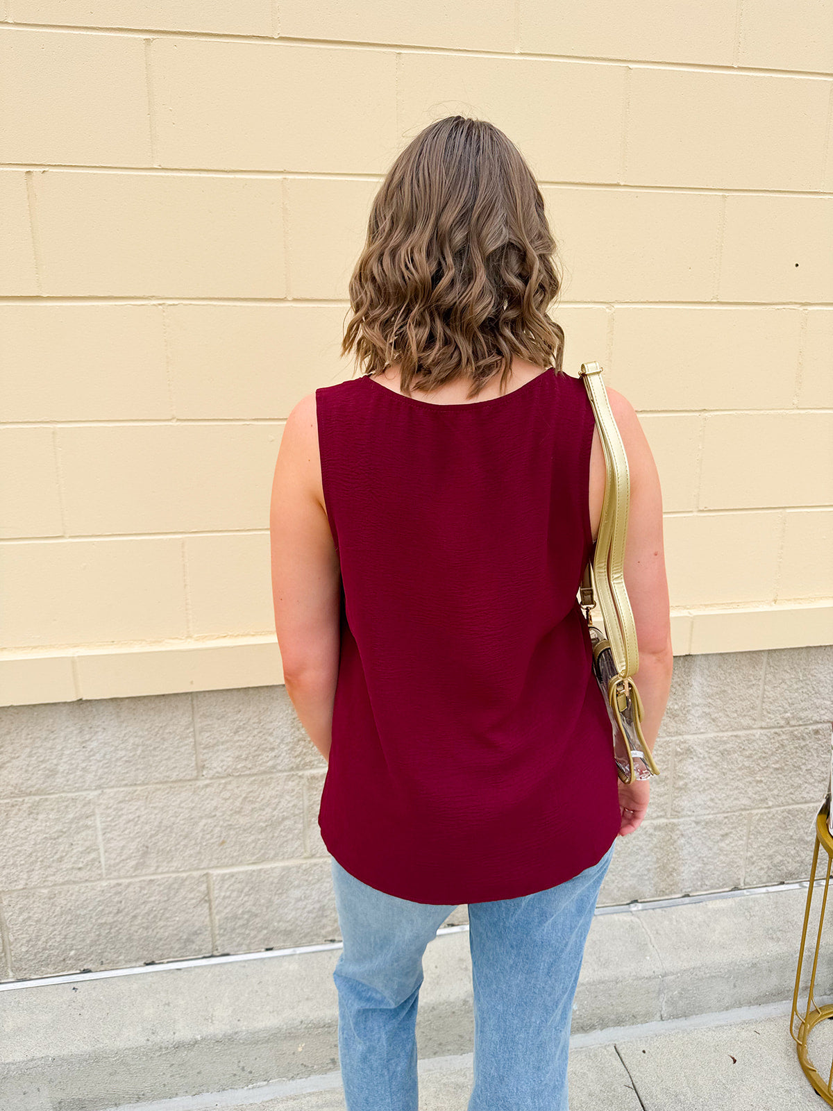 Garnet sleeveless V-neck tank with pleated detail at neckline, made in USA fabric.