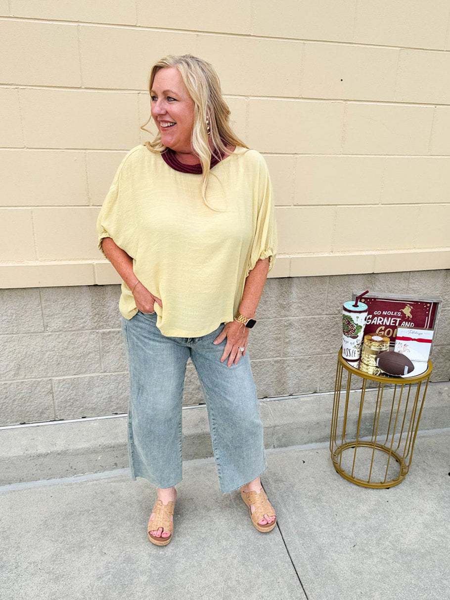 Golden yellow short sleeve blouse with a relaxed fit and dolman sleeves, styled for casual or dressy occasions.