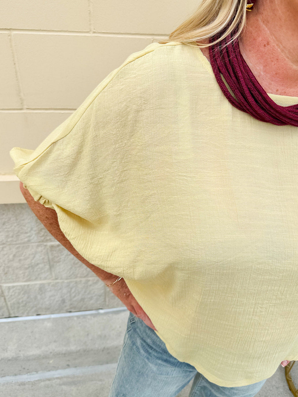 Golden yellow short sleeve blouse with a relaxed fit and dolman sleeves, styled for casual or dressy occasions.
