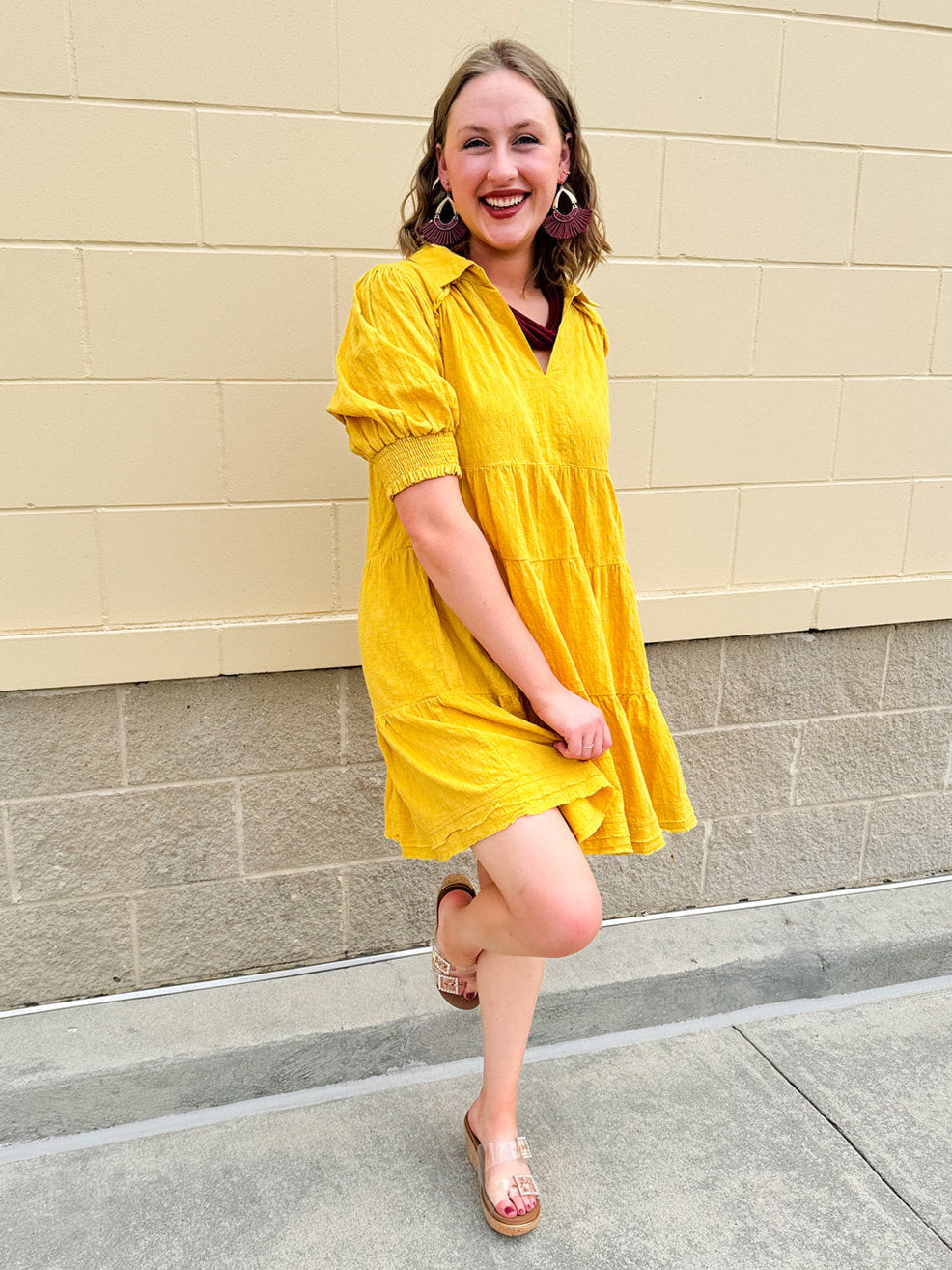 Mustard cotton mini dress with a collar, tiered A-line shape, and smocked cuff balloon sleeves—perfect for gameday style.