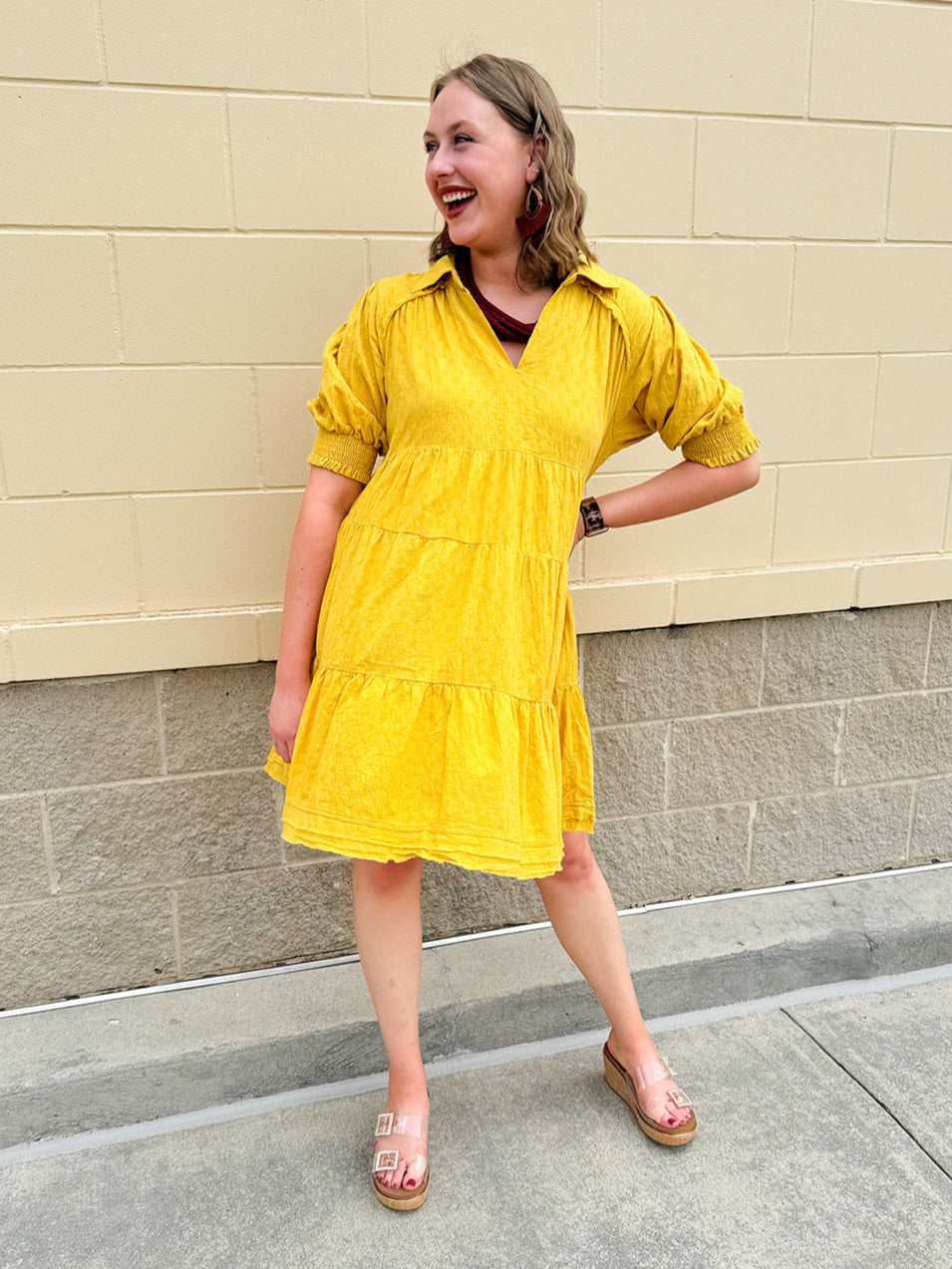 Mustard cotton mini dress with a collar, tiered A-line shape, and smocked cuff balloon sleeves—perfect for gameday style.
