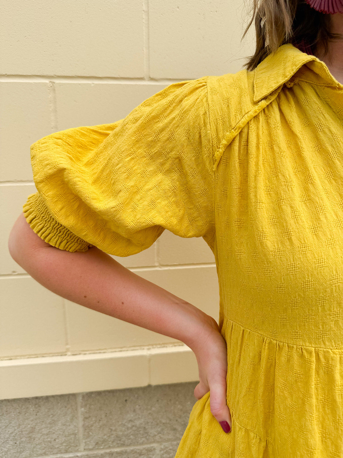 Mustard cotton mini dress with a collar, tiered A-line shape, and smocked cuff balloon sleeves—perfect for gameday style.