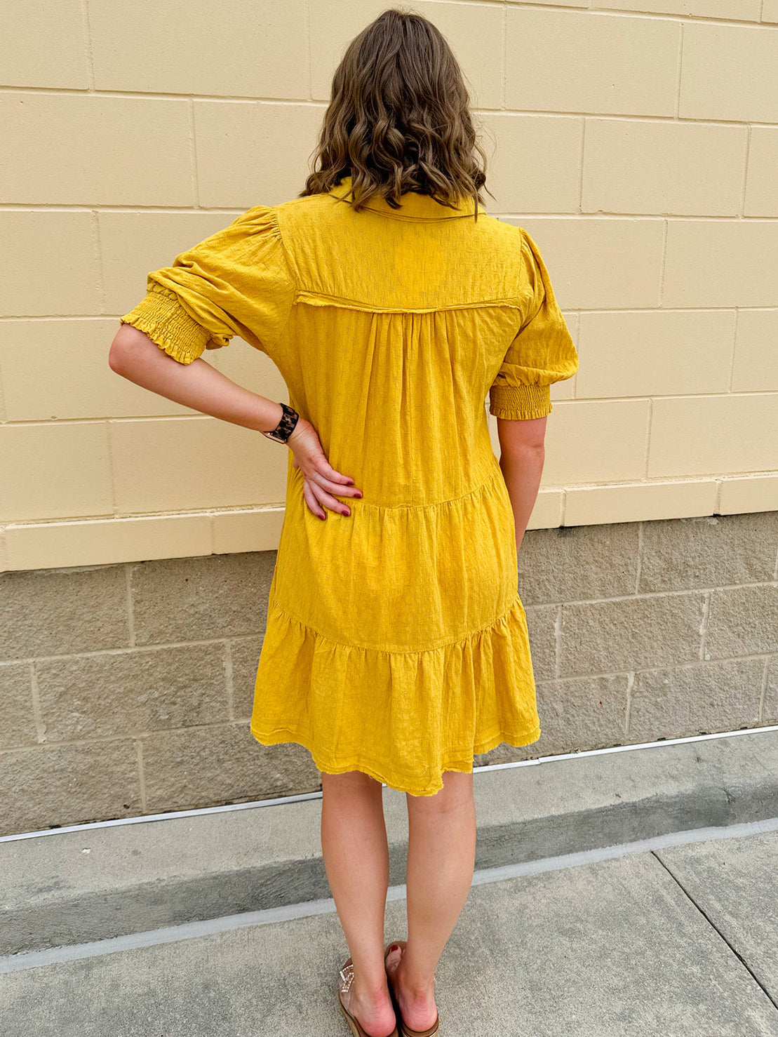 Mustard cotton mini dress with a collar, tiered A-line shape, and smocked cuff balloon sleeves—perfect for gameday style.