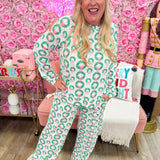 Pink and white striped pajama set with green wreath and pink bow pattern, long-sleeve top, and drawstring pants.