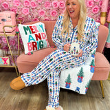 White pajama set with nutcracker and Christmas tree print, blue piping, and drawstring pants.