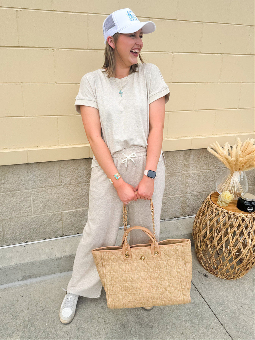 Taupe short sleeve knit top with ribbed collar and cuffed sleeves, styled casually with matching knit pants.