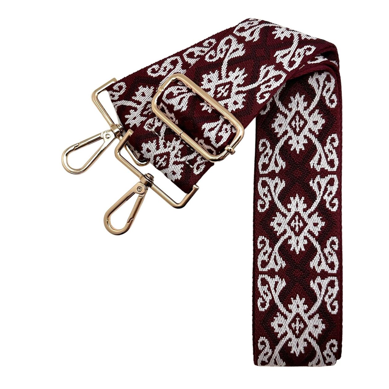 Fabric purse strap with garnet background and black and white design, gold hardware.