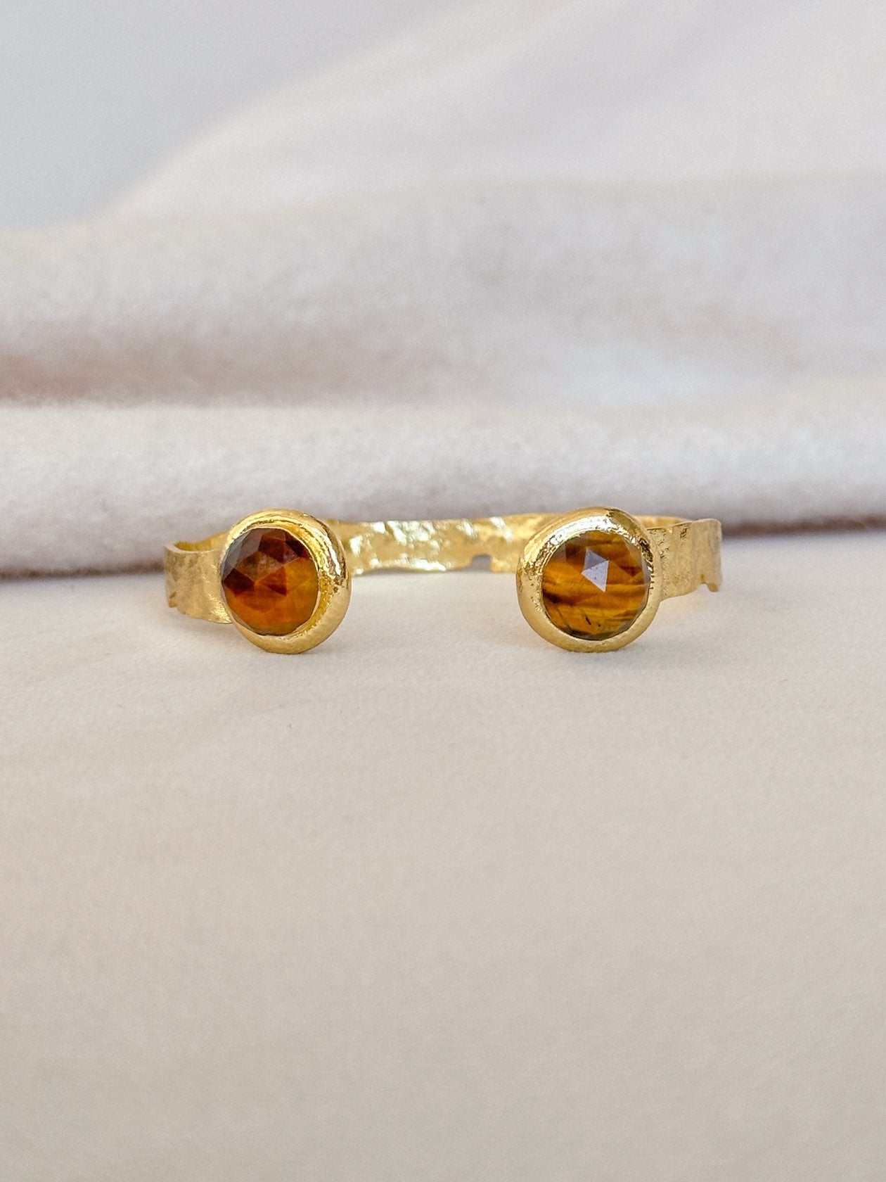 Gold cuff with two round tigers eye stones.