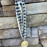 White and black houndstooth patterned scarf necklace with gold border and gold medallion pendant, handmade by Hart Designs.