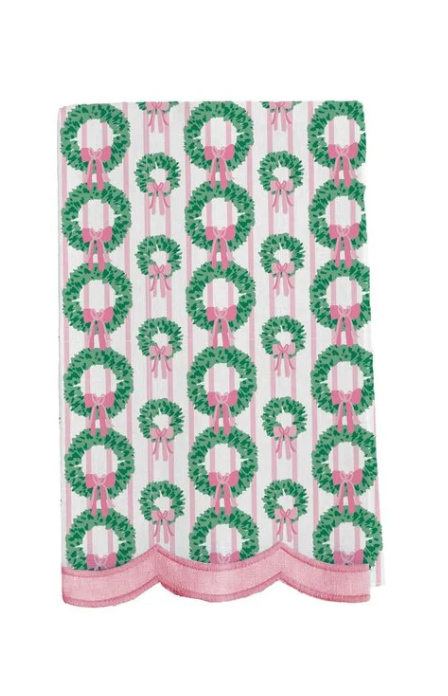 White Christmas tea towel with green wreaths, pink bows, pink stripes, and scalloped pink trim.