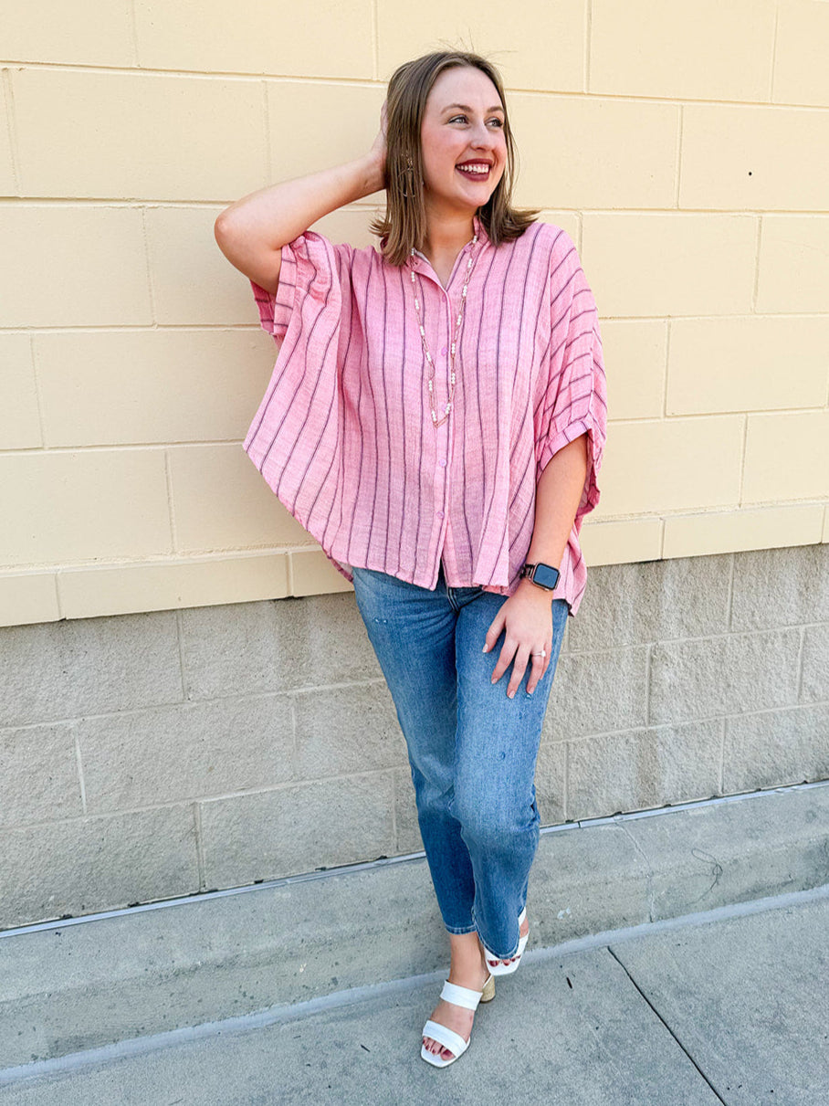 Oversized pink striped cotton gauze blouse with collar, button-down front, drop shoulders, and half sleeves.