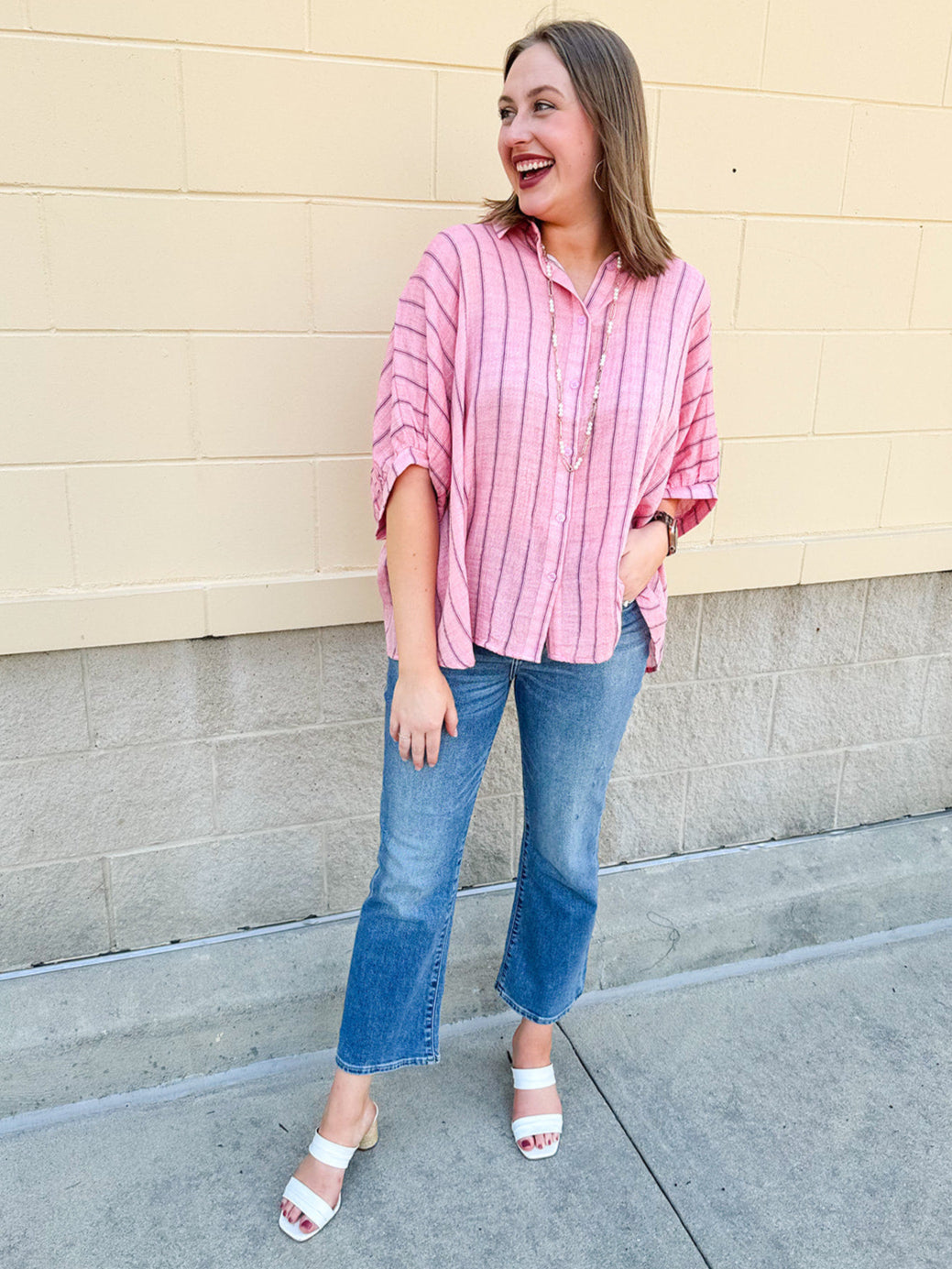 Oversized pink striped cotton gauze blouse with collar, button-down front, drop shoulders, and half sleeves.