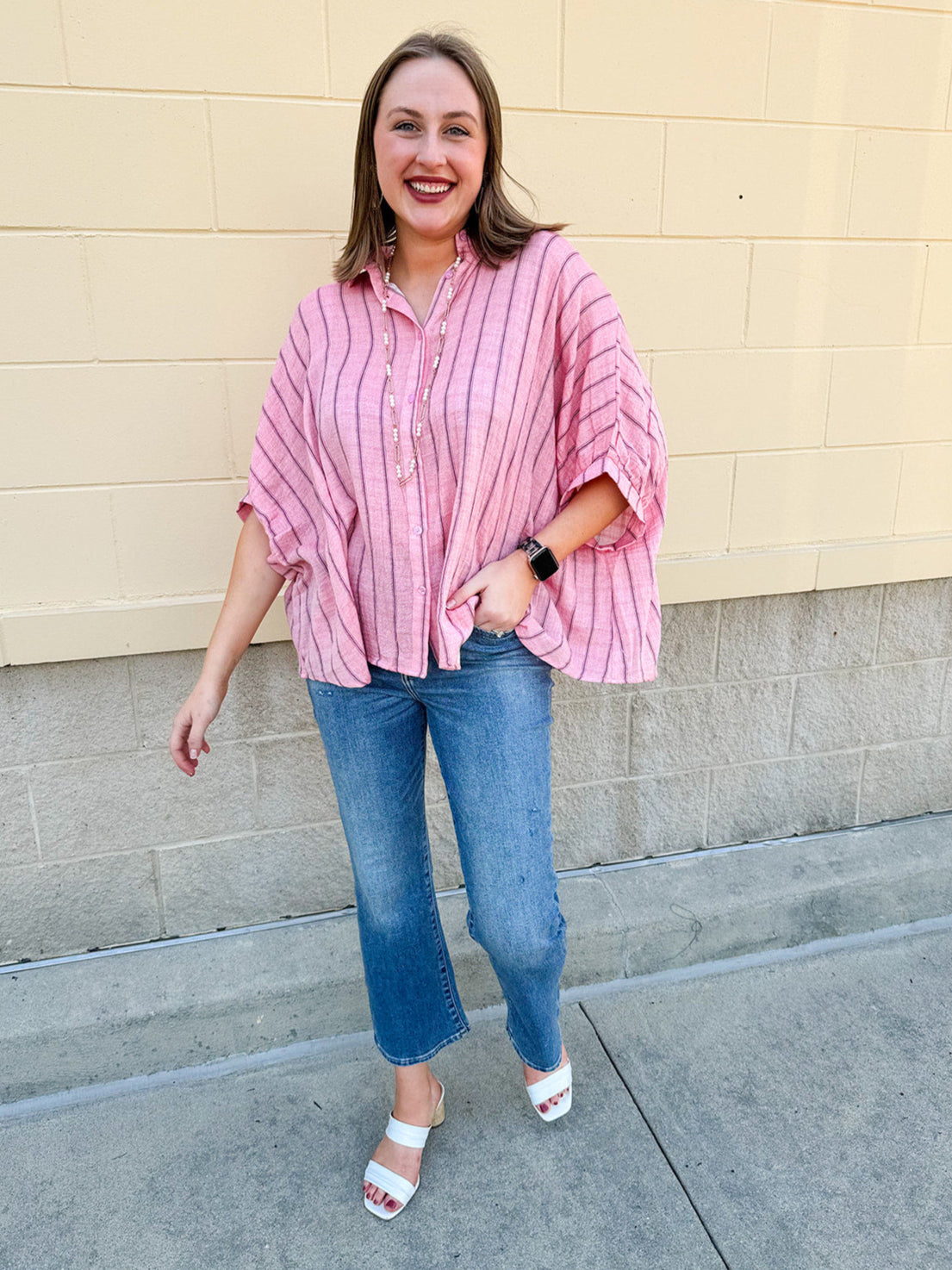 Oversized pink striped cotton gauze blouse with collar, button-down front, drop shoulders, and half sleeves.