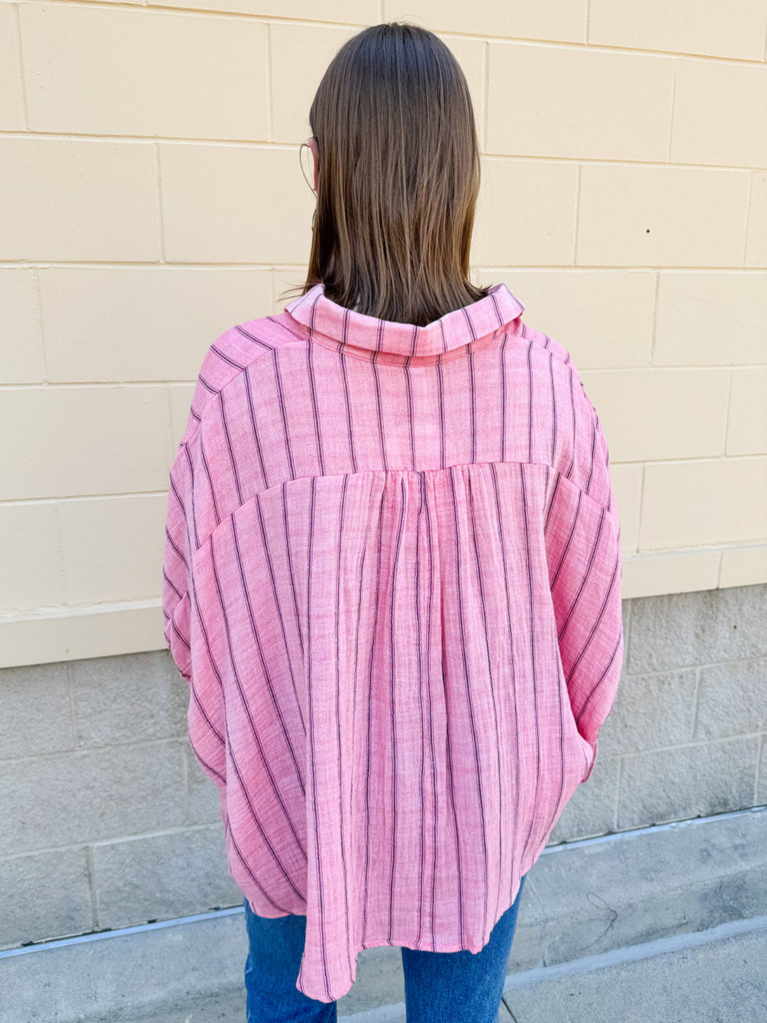 Oversized pink striped cotton gauze blouse with collar, button-down front, drop shoulders, and half sleeves.