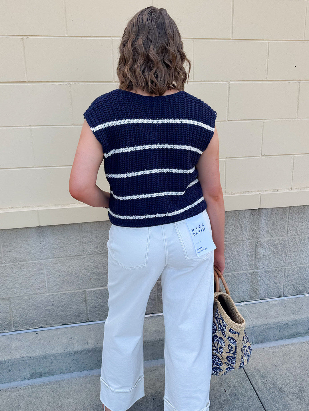 Navy and white striped crochet vest with front pockets, buttons, and sleeveless relaxed fit.