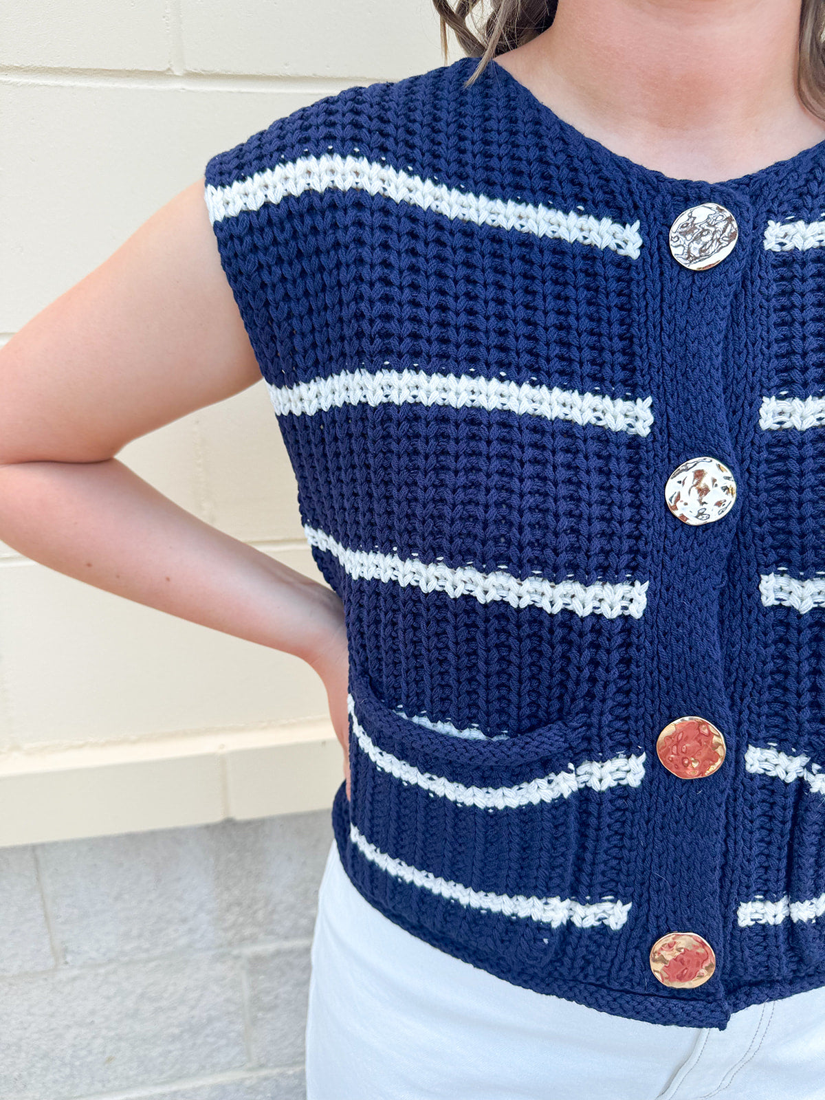 Navy and white striped crochet vest with front pockets, buttons, and sleeveless relaxed fit.