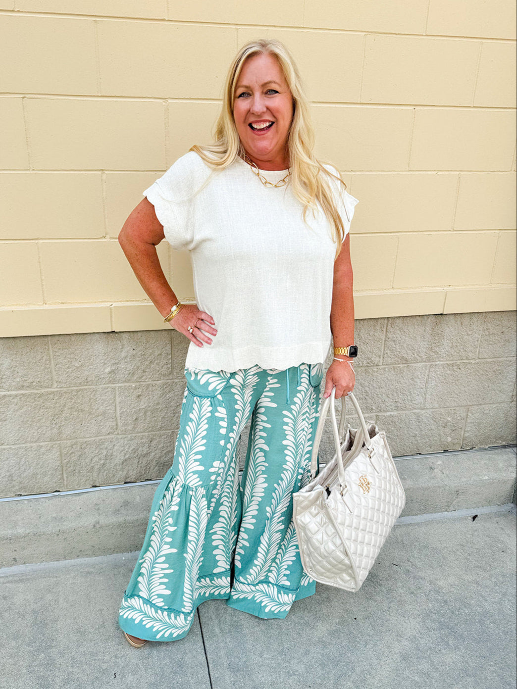 Lightweight printed wide-leg pants with a tropical pattern in dusty blue and cream tones, featuring a drawstring waist and pockets.