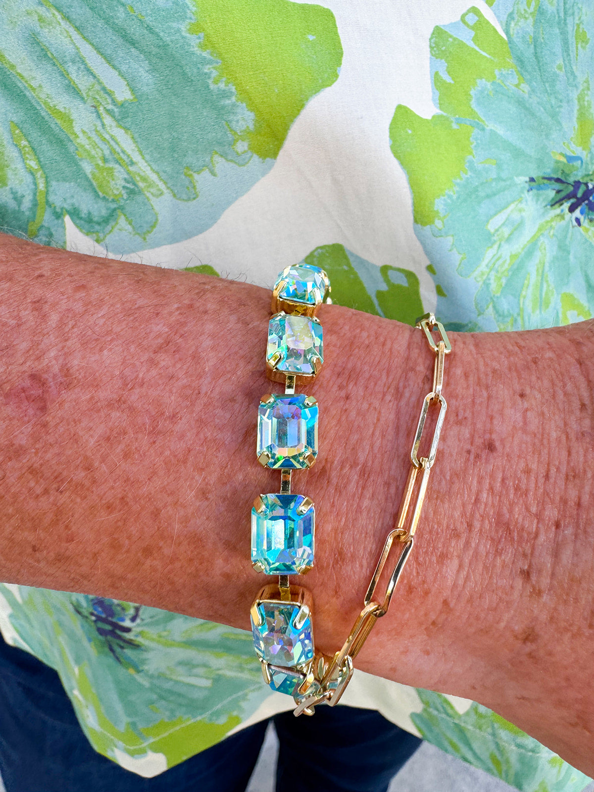 Bright gold-tone tennis bracelet featuring emerald-cut Aqua Aurora Borealis crystals from Sorrelli’s Octavia design.