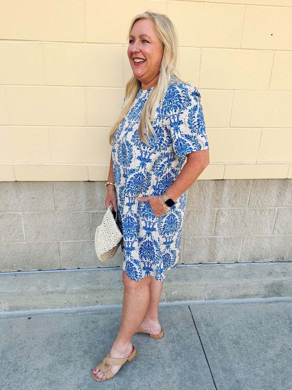 Blue and white damask print short-sleeve mini dress with pockets and back zipper closure, styled for a casual yet polished look.