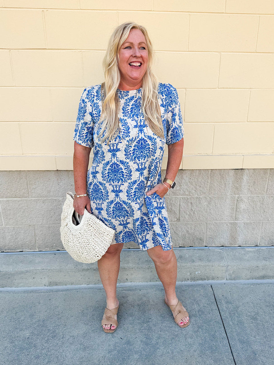Blue and white damask print short-sleeve mini dress with pockets and back zipper closure, styled for a casual yet polished look.