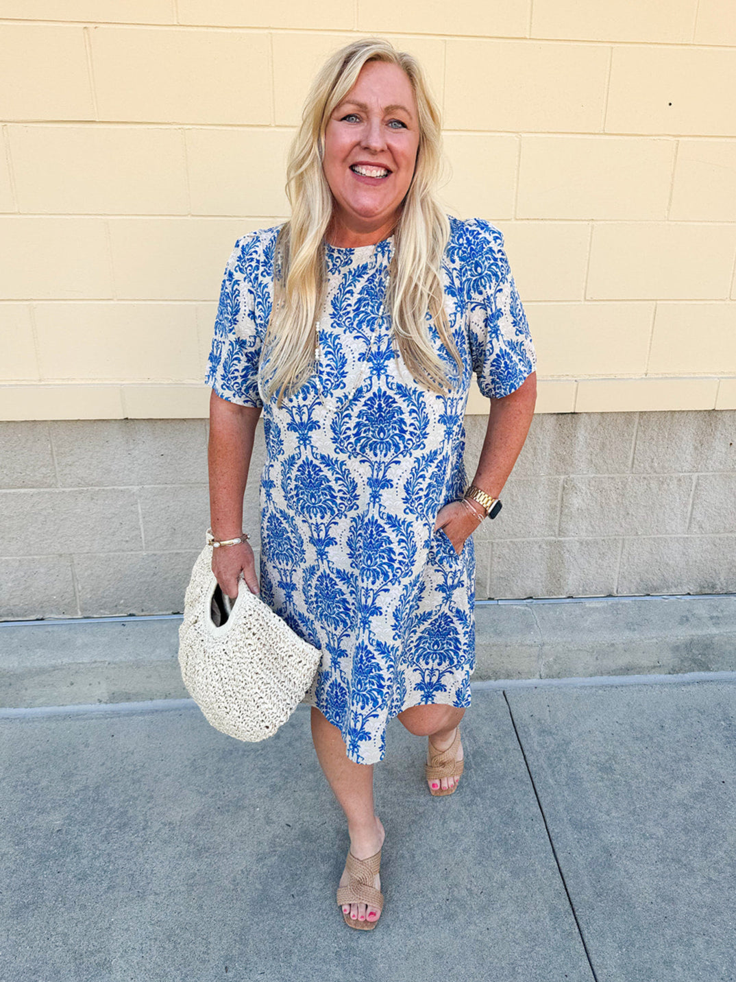 Blue and white damask print short-sleeve mini dress with pockets and back zipper closure, styled for a casual yet polished look.