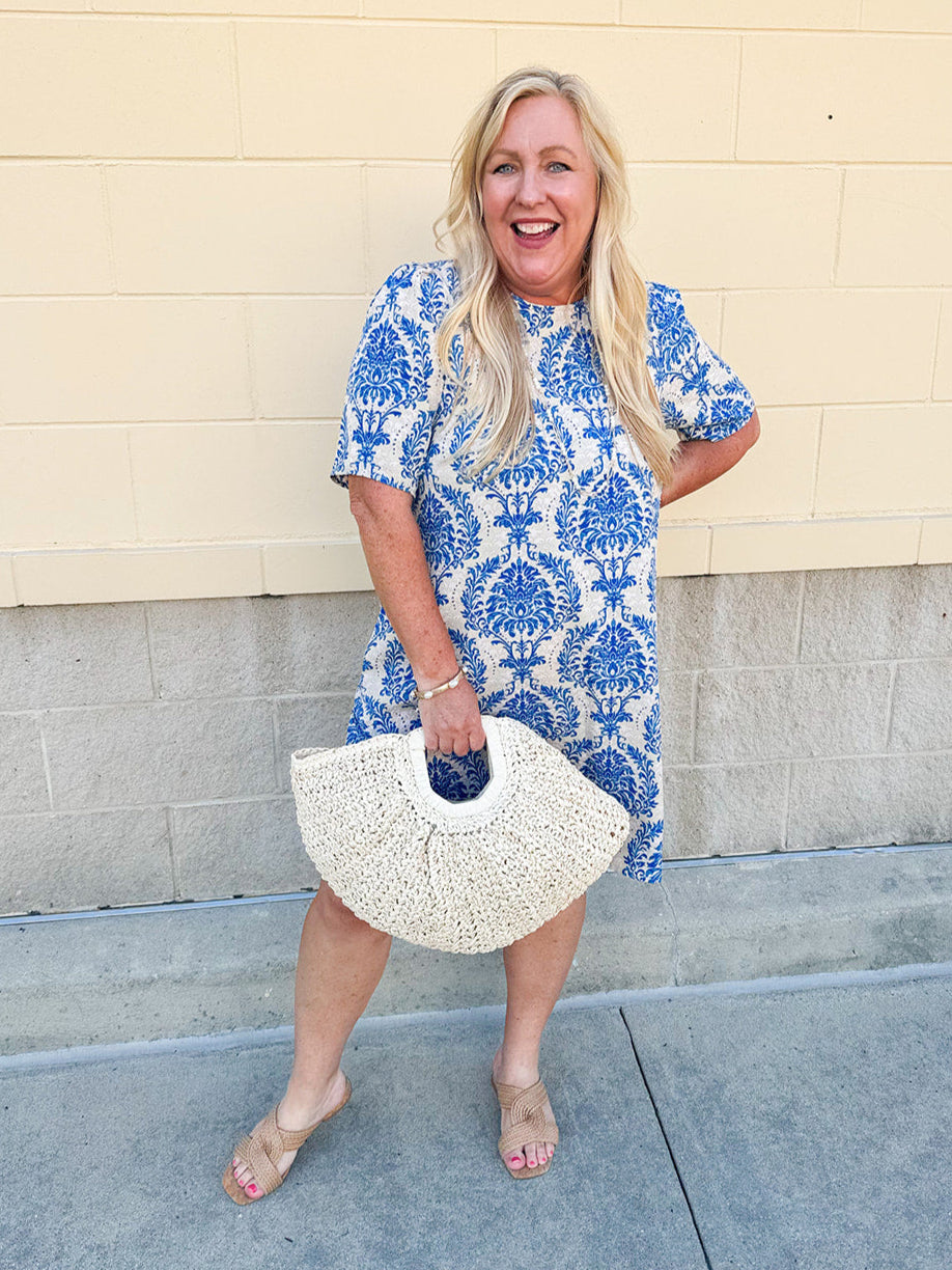 Blue and white damask print short-sleeve mini dress with pockets and back zipper closure, styled for a casual yet polished look.