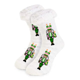 Soft slipper socks with pink and green nutcracker design holding champagne bottles, fluffy cuff, and grip bottoms.