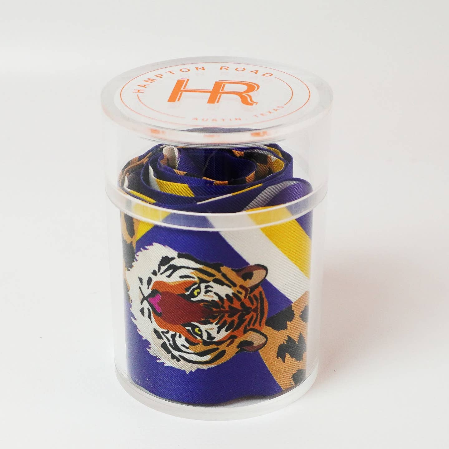 Scarf with tiger design in a clear container on a white background