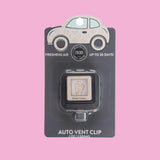 Compact car vent clip styled in a vehicle interior with neutral tones