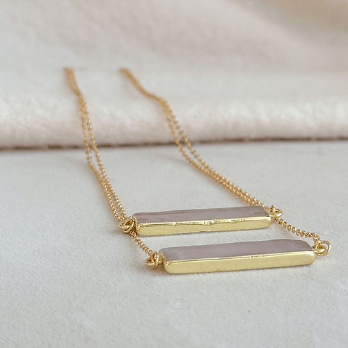 Gold necklace with a horizontal rose-hued bar, designed for delicate layering and soft, feminine elegance.